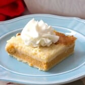 slice of Pumpkin Pie Cobbler with whipped cream on a blue plate with