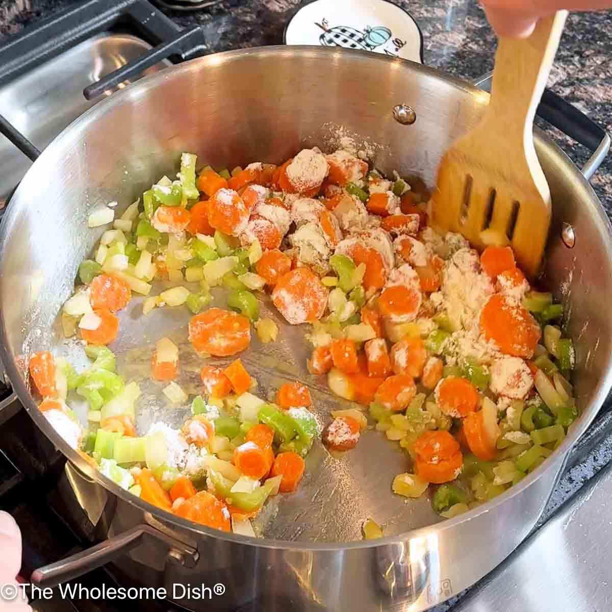 Stirring flour and minced garlic into the pot.