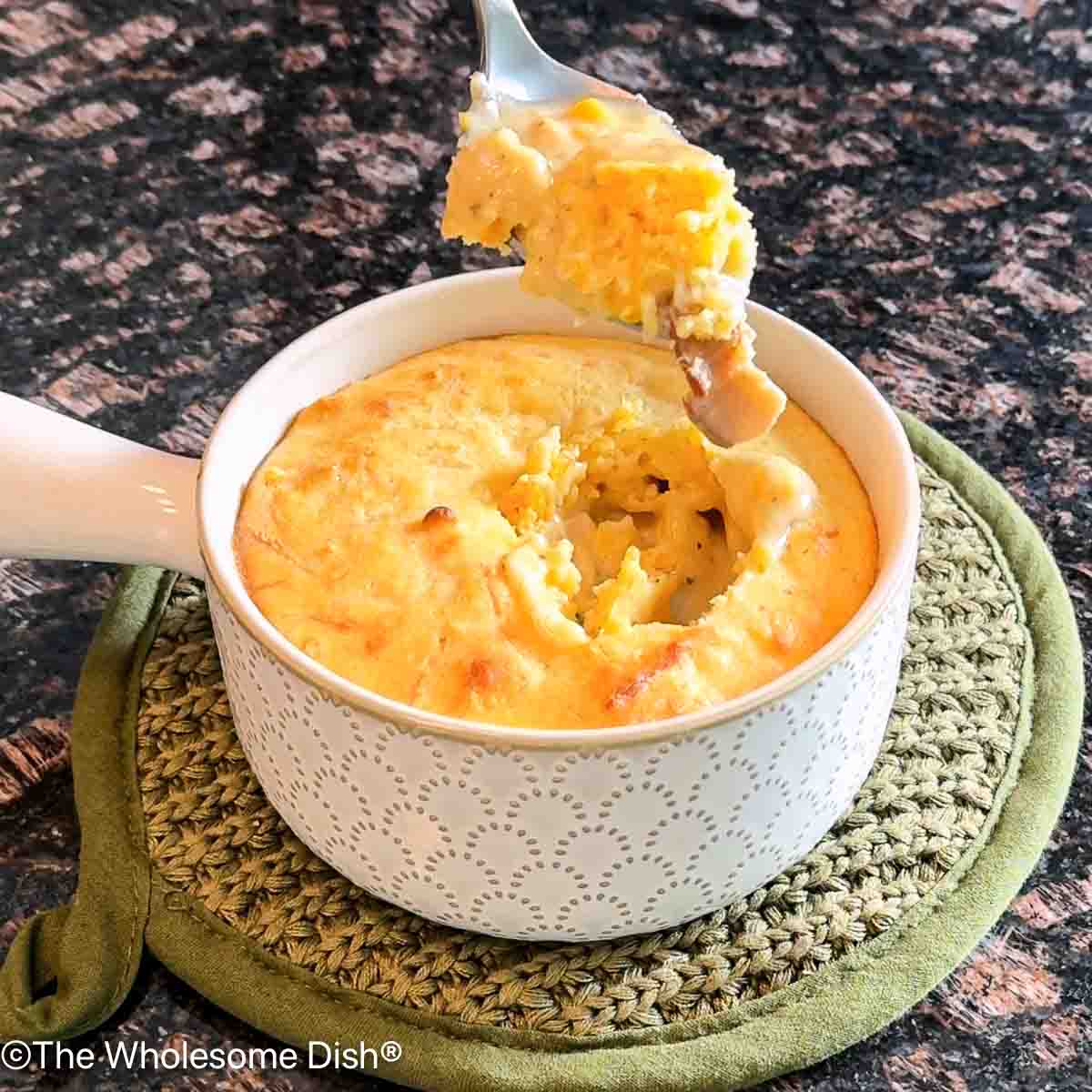 White bowl of chicken bacon ranch corn chowder topped with a cheddar cornbread crust.