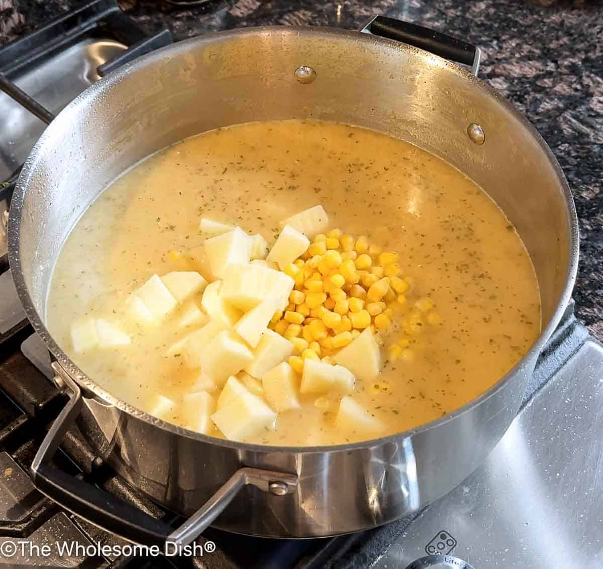 Adding corn kernels and chopped potatoes.