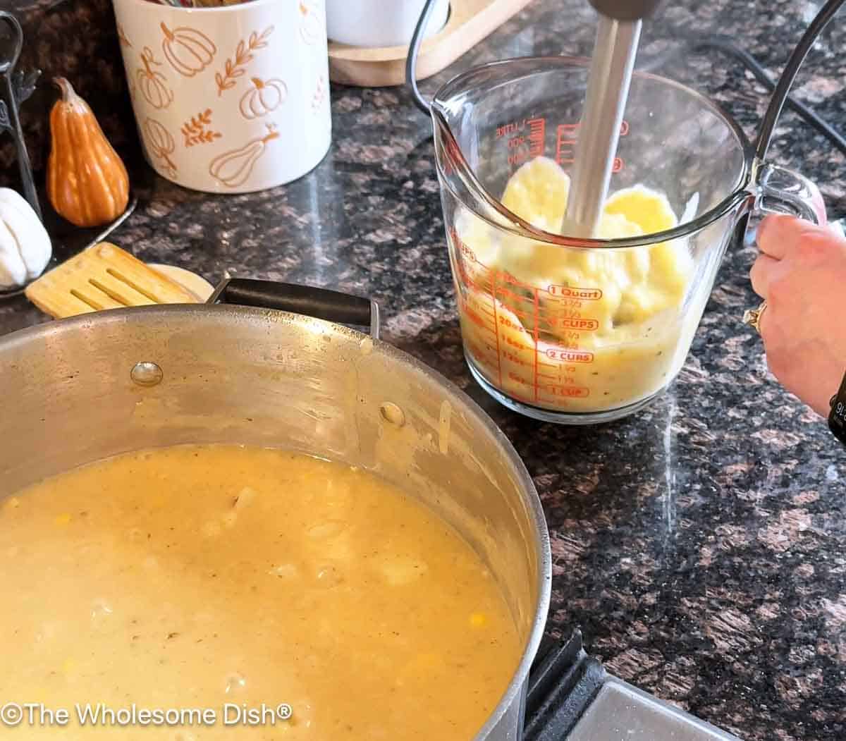 Blending part of the soup in a large measuring cup with an immersion blender.