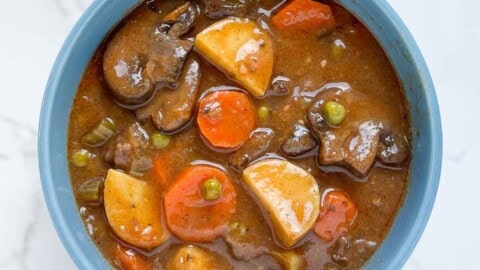 Beef stew in a blue bowl.