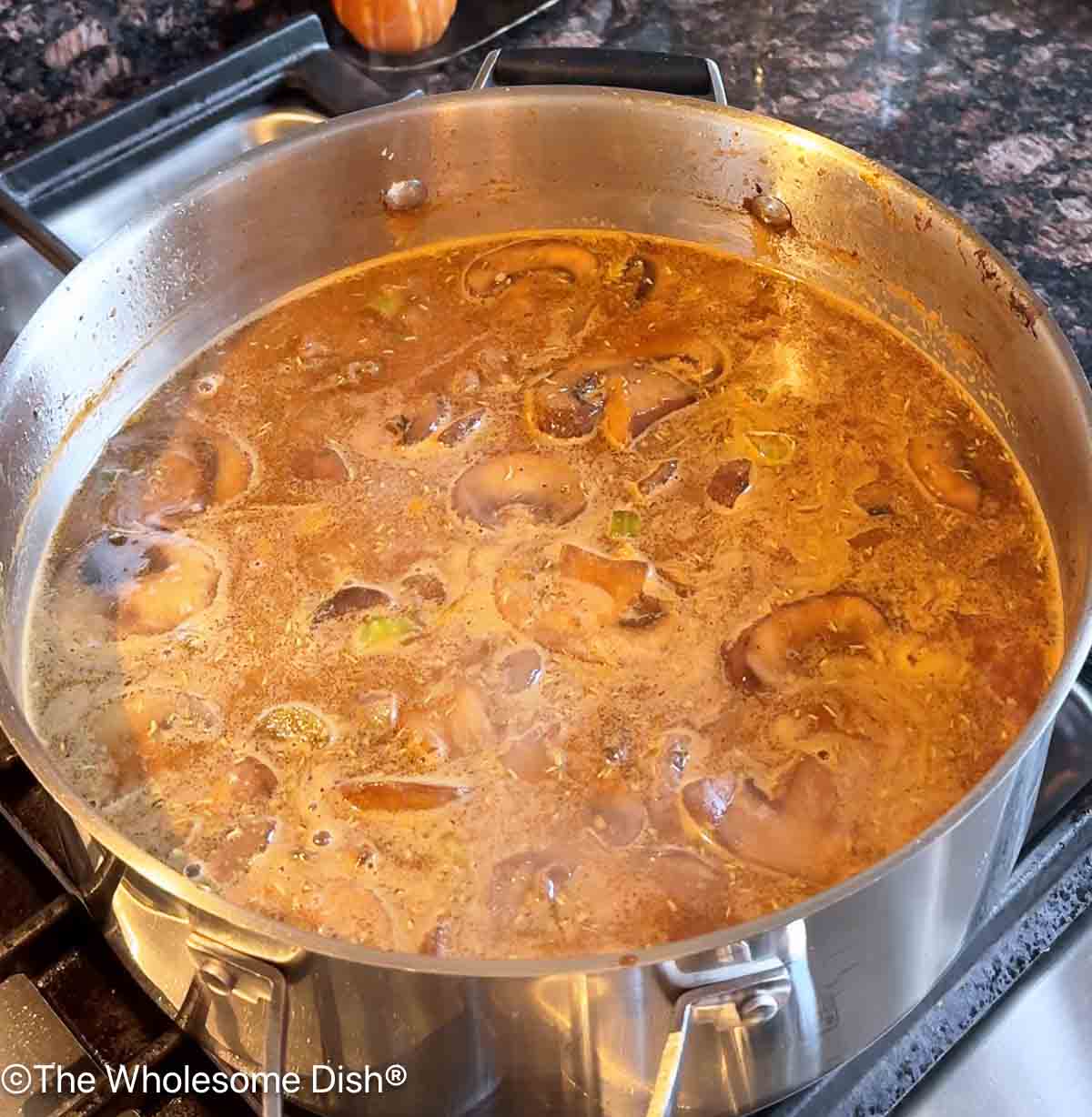 Beef broth and beef stew meat added to the pot.